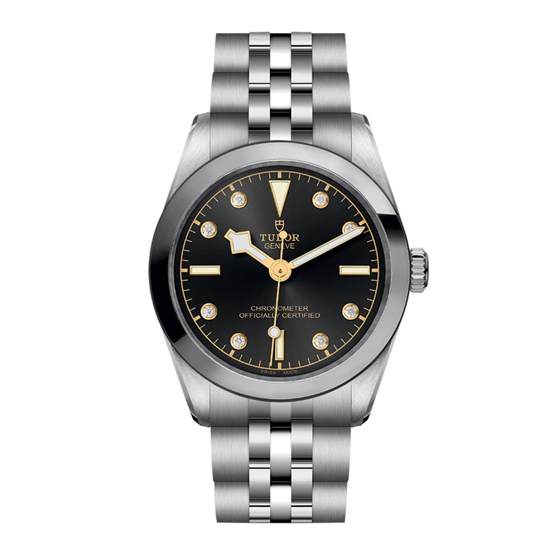 The TUDOR Black Bay 31 is a chic unisex watch with a stainless steel bracelet, black dial, gold accents, and round hour markers—shown stylishly against a white background.