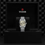 The TUDOR Black Bay One 31 unisex watch, featuring a silver dial and metal bracelet, is showcased upright in an open black TUDOR presentation box, highlighting the brand’s refined technical watchmaking.