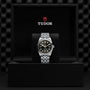 The TUDOR Black Bay One 36 wristwatch, showcasing technical refinement, is displayed upright in a black presentation box with the TUDOR logo inside the lid.