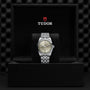 The TUDOR Black Bay One 36 unisex watch with a silver dial and metal bracelet is displayed upright in an open black box featuring the TUDOR logo inside the lid, reflecting the elegant style of Black Bay models.