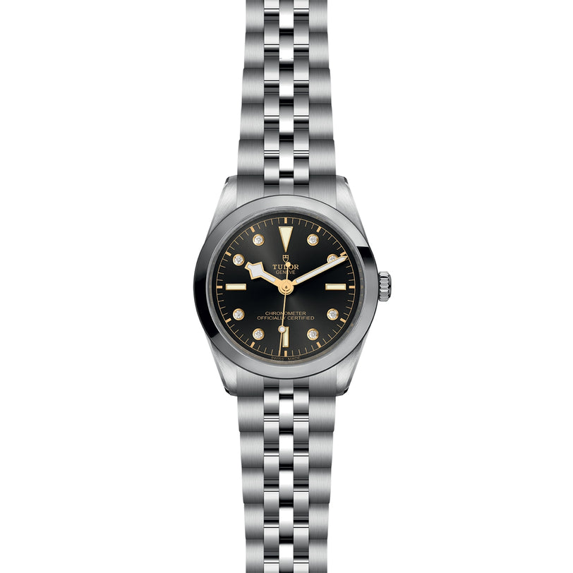 A TUDOR Black Bay One 36 wristwatch with a silver case, black dial, and metal bracelet is displayed on a white background.