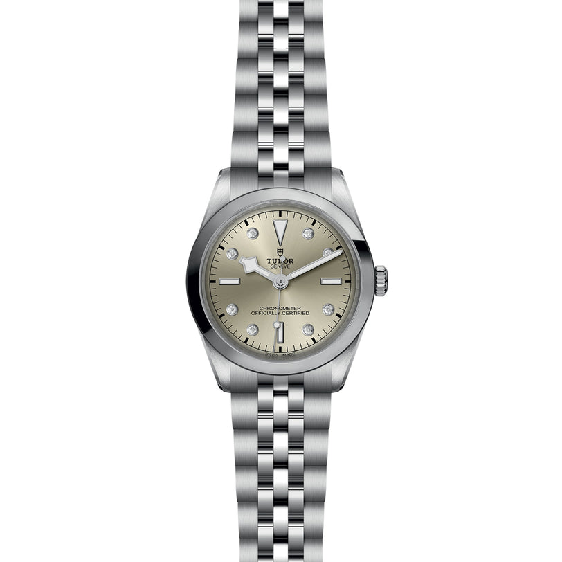 The TUDOR Black Bay One 36 is a silver wristwatch with a 316L steel bracelet, champagne dial accented by diamond hour markers, and a black bezel, reflecting the sophisticated style of the Black Bay collection.