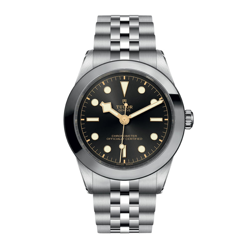 The TUDOR Black Bay One 39 wristwatch features a stainless steel case, black dial with luminescent markers, and a silver metal link bracelet, showcasing unisex style against a white background.