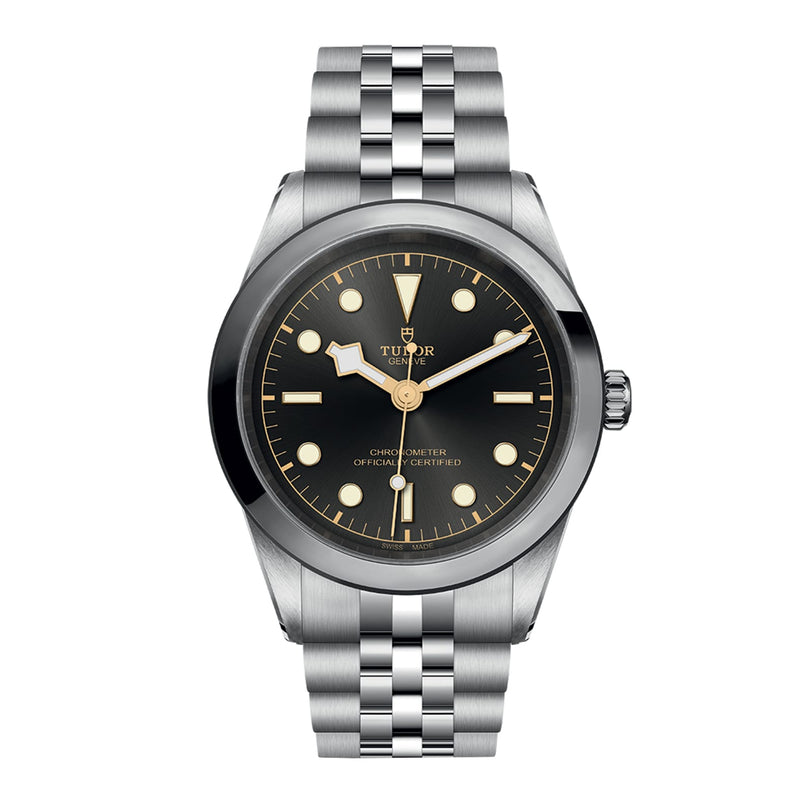 The TUDOR Black Bay One 41, a stainless steel wristwatch with a black dial, luminous markers, and metal bracelet, showcases unisex style and is photographed against a white background.