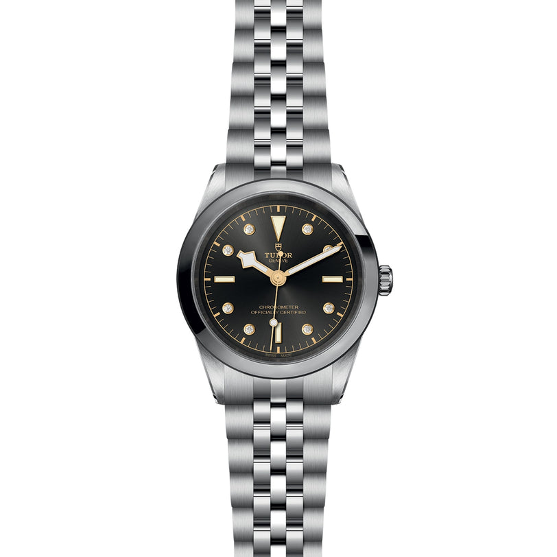 The TUDOR Black Bay One 41 is a unisex wristwatch made from 316L steel, featuring a black dial, round gold hour markers, silver hands, a metal link bracelet, and the brand logo and text on the watch face.