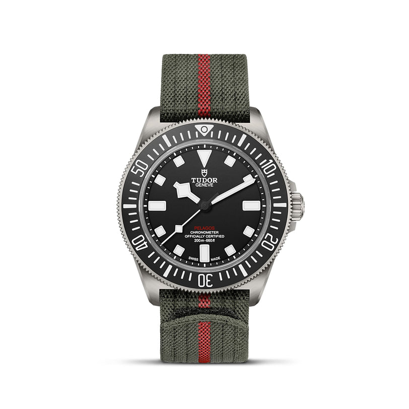The TUDOR Pelagos FXD is a military-inspired wristwatch featuring a black dial, white markers, rotating bezel, and an olive green fabric strap with a red stripe.