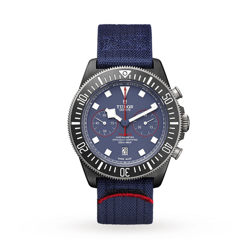 The TUDOR Pelagos FXD Chrono is a blue dive watch with a fabric strap, black bezel, and red accents on the dial and strap.