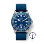 The TUDOR Pelagos FXD dive watch features a blue dial and bezel, blue fabric strap, titanium case, and the Marine Nationale logo in the lower right corner.