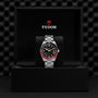 A TUDOR Black Bay 58 GMT wristwatch with a black and red bezel is shown in an open black box featuring the TUDOR logo on the inside lid.