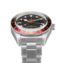 A TUDOR Black Bay 58 GMT stainless steel wristwatch with a black dial, red and black bezel, and metal bracelet, shown against a white background.