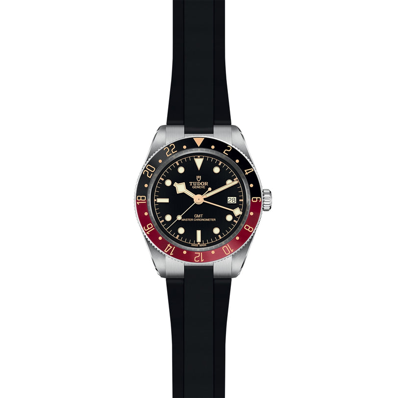 The TUDOR Black Bay 58 GMT features a black and red bezel, black dial, silver case, date at 3 o’clock, and a black rubber strap—capturing the signature style of TUDOR’s iconic GMT dive watch.