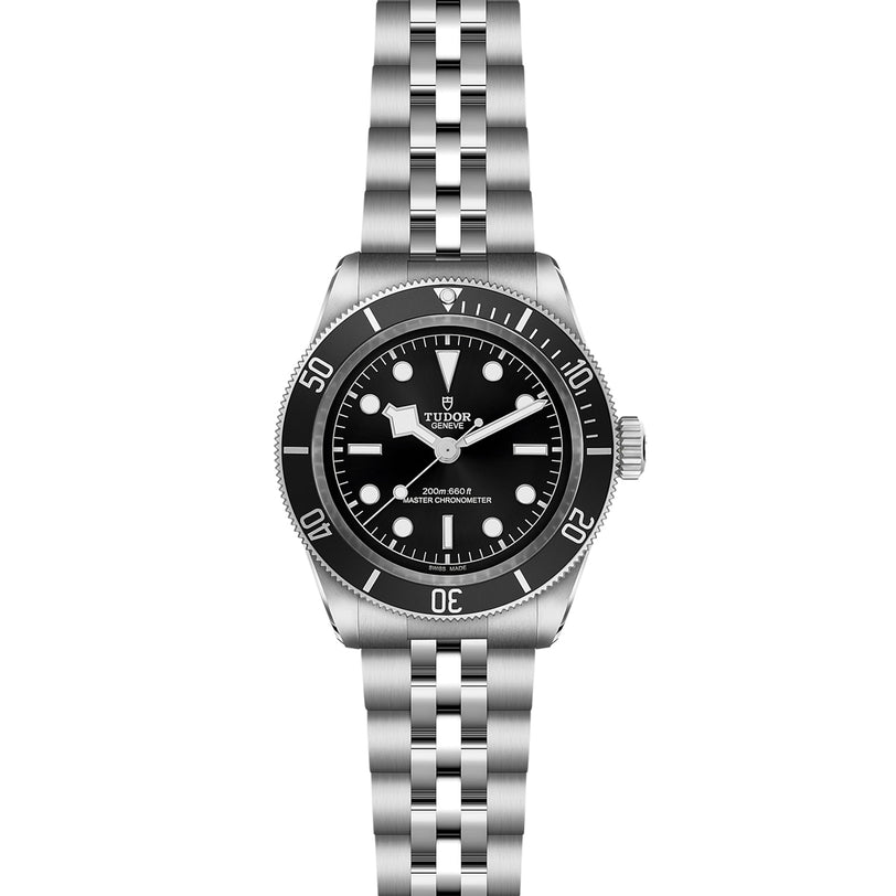 The TUDOR Black Bay wristwatch features a stainless steel case, black dial with white hour markers, and a silver bezel on a metal bracelet, merging classic style with the diving heritage of the TUDOR Black Bay line.
