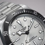 Close-up of a TUDOR Black Bay 68 dive watch featuring a silver dial, black bezel, and displaying the time 4:39.