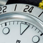 Close-up of the TUDOR Black Bay Pros silver bezel featuring numbers 22 and 24, with part of the white watch face and markers in view.