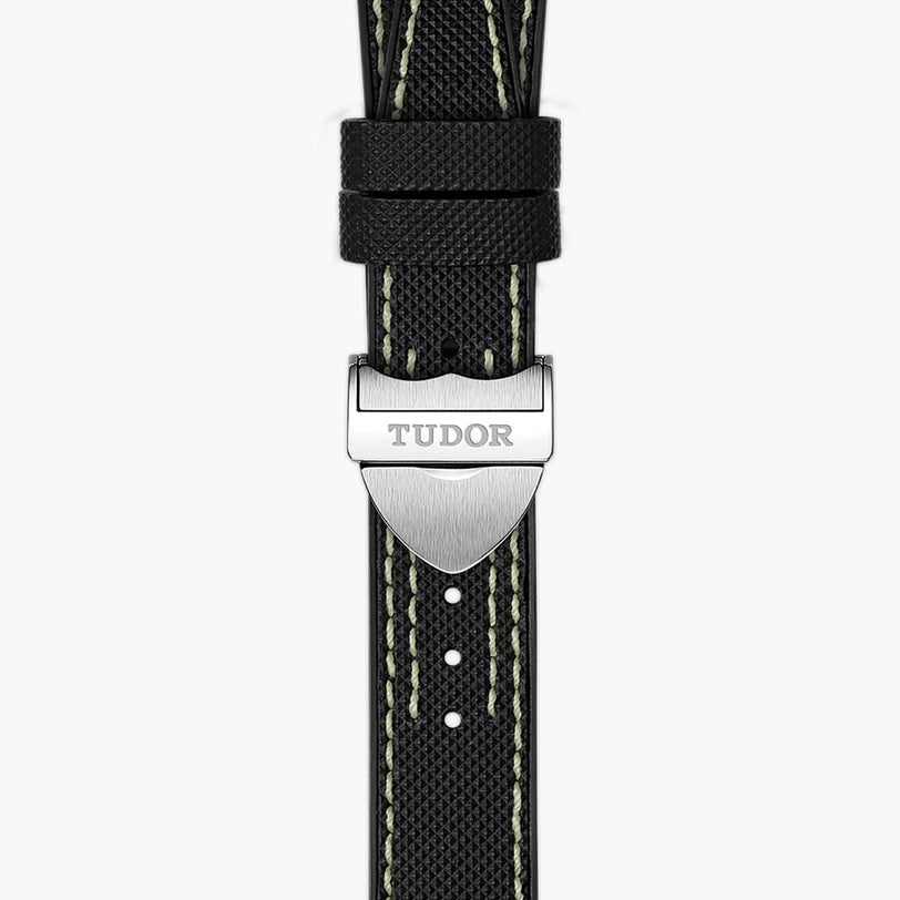 Close-up of a TUDOR Black Bay Pro black watch strap with white stitching and a silver TUDOR buckle.