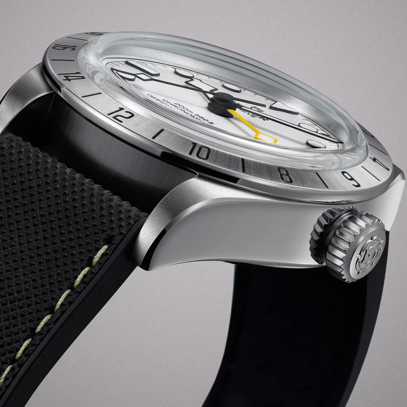 Close-up of the TUDOR Black Bay Pro, featuring a silver case, black textured strap, and a yellow-tipped second hand.