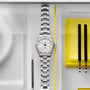 The TUDOR Black Bay Pro wristwatch is displayed beside watchmaking tools on a white and yellow background.