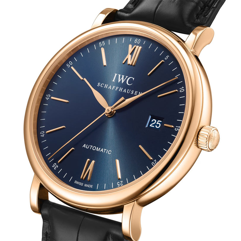 The IWC Schaffhausen Portofino Automatic features a gold case, blue dial with Roman numerals, date window at 3 o’clock, black leather strap, and Swiss automatic self-winding movement.