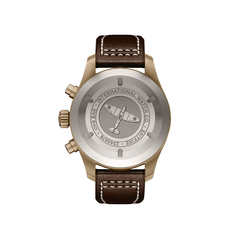 Back view of the IWC Schaffhausen Pilots Watch Chronograph Spitfire with a brown leather strap and bronze case, showing engraved text and an airplane illustration on the metal case back.