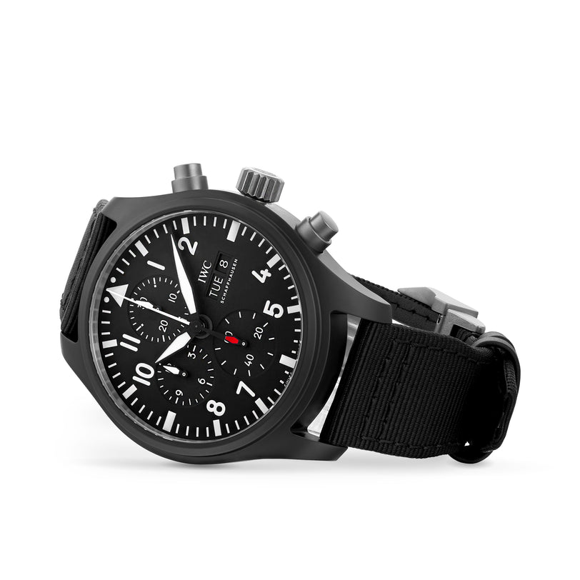 An IWC Schaffhausen Pilots Watch Chronograph Top Gun wristwatch with a black fabric strap, white hour markers, three subdials, and two pushers, shown on a white background.