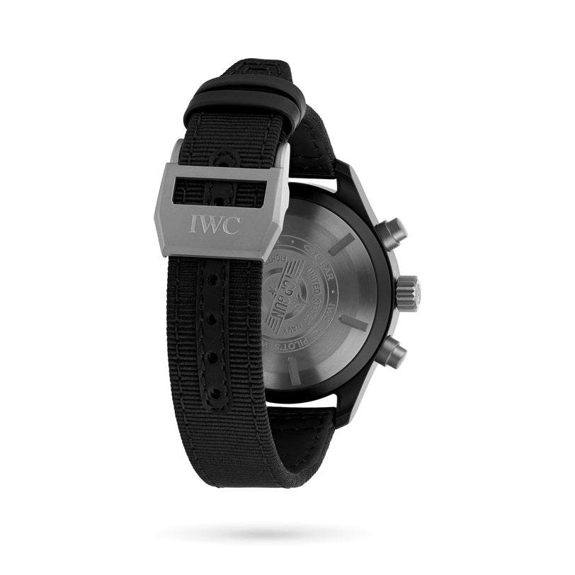 The image shows the back view of the IWC Schaffhausen Pilots Watch Chronograph Top Gun, featuring a black fabric strap, visible metal buckle, and engraved details on the case back.