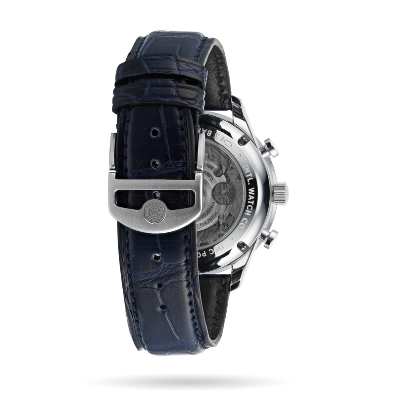 A close-up of a dark blue leather watch strap and stainless steel buckle reveals the back of an IWC Schaffhausen Portugieser Chronograph, showcasing mechanical details, visible 69355 calibre, and engraved markings.