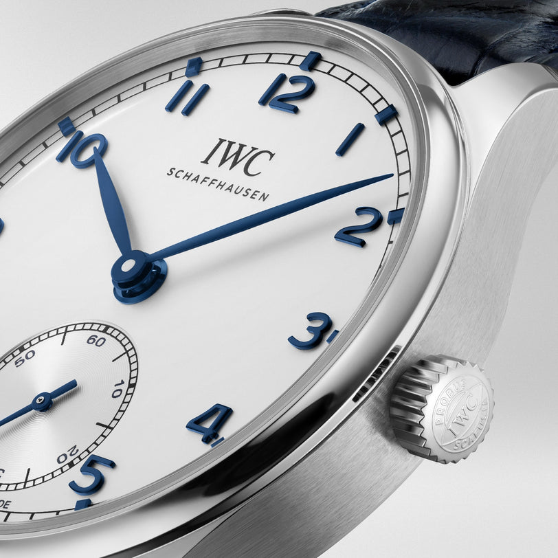 Close-up of an IWC Schaffhausen Portugieser Automatic 40 wristwatch featuring a white dial, blue hands and numerals, and a crown engraved with the brand logo.