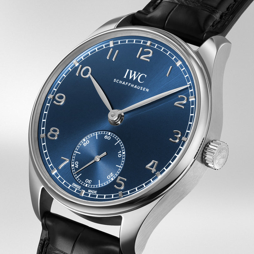 Close-up of an IWC Schaffhausen Portugieser Automatic 40 wristwatch featuring a blue dial, silver numerals and hands, small seconds subdial, and black leather strap.