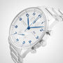 An IWC Schaffhausen Portugieser Chronograph wristwatch with a white dial, blue accents, two subdials, stainless steel bracelet, and IWC 69355 calibre is displayed at an angle on a light background.