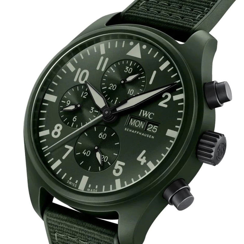 The IWC Schaffhausen Pilot’s Watch Chronograph TOP GUN Edition “Woodland” features a green dial with three subdials, white accents, fabric strap, and displays Monday the 25th.