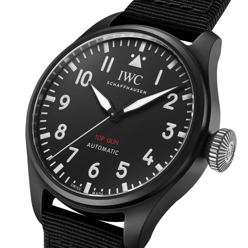 Close-up of the IWC Schaffhausen Big Pilots Watch 43 Top Gun, featuring a black zirconium oxide ceramic case, white numerals, red TOP GUN text, and a black fabric strap. The watch displays 10:08.