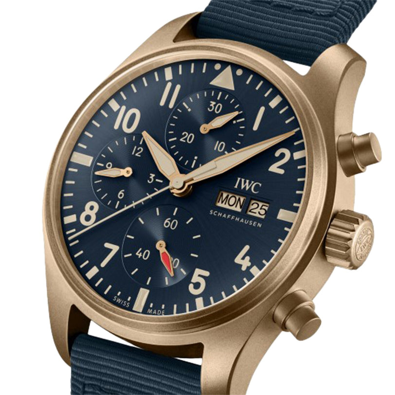 The IWC Schaffhausen Pilots Watch Chronograph 41 features a gold-tone case, blue dial with three subdials, day and date windows, and a blue fabric strap. The watch displays the IWC Schaffhausen logo on its face.