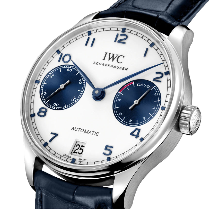 A close-up of an IWC Schaffhausen Portugieser Automatic watch featuring a white dial, blue numerals, two subdials, date display, and a blue alligator leather strap.