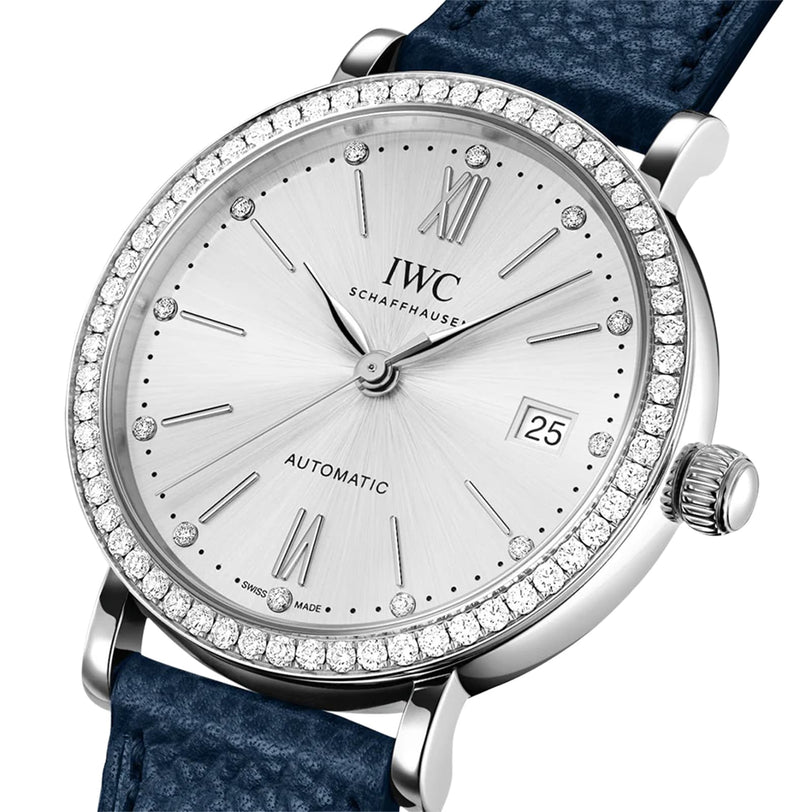 The IWC Schaffhausen Portofino Automatic 37 features a silver case, diamond bezel, Roman numerals, date display, and a blue textured strap.