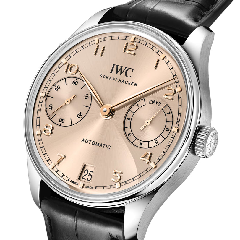 A close-up of the IWC Schaffhausen Portugieser Automatic 42 wristwatch with a gold dial, Arabic numerals, subdials for seconds and days, date window, black leather strap, and stainless steel case.