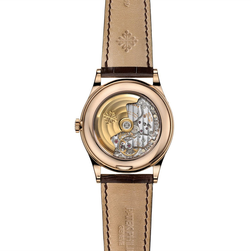 The Patek Philippe Complication 5396R-011 is a luxury watch featuring a brown leather strap and a transparent back that displays its intricate mechanical movement.