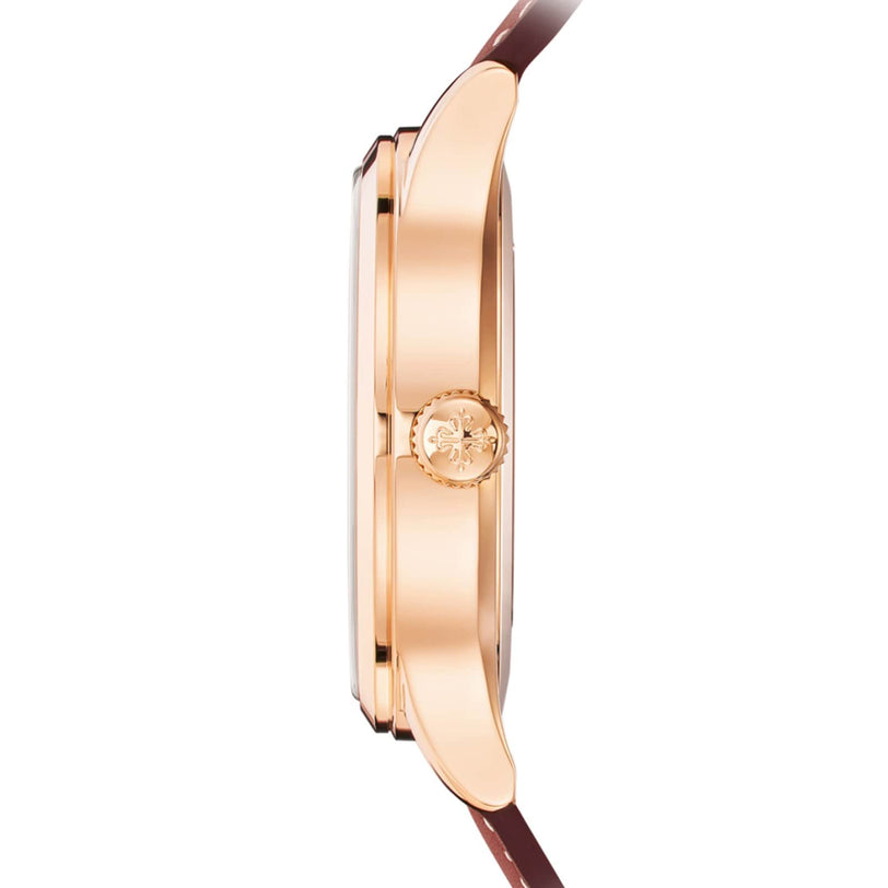 Side view of the Patek Philippe Calatrava 5524R-001 featuring a gold case, brown leather strap, and an engraved crown.