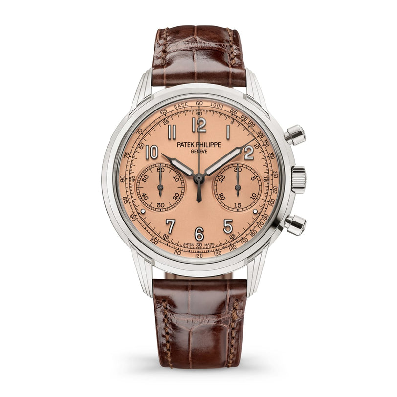 The Patek Philippe Complication 5172G-010 is a luxury watch with a salmon dial, brown leather strap, silver case, two subdials, and three pushers.
