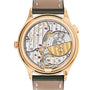 The Patek Philippe Complication 7130R-014 features a gold luxury case back revealing intricate mechanical movement and gears, complemented by an elegant leather strap.