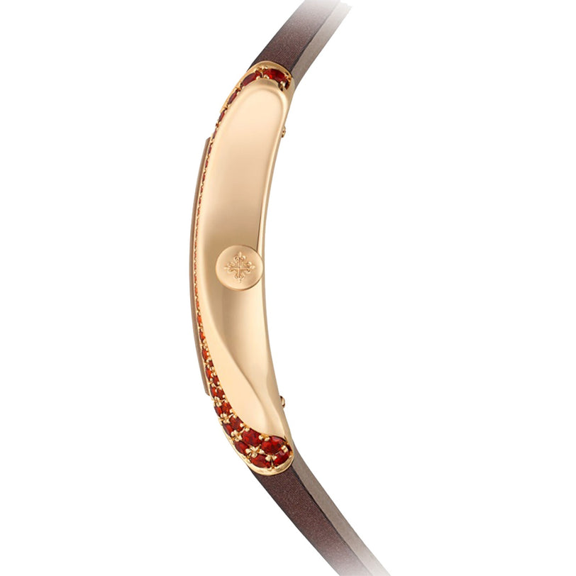 Side view of the Patek Philippe Gondolo 4962/200R-001, an elegant gold watch with a brown strap and red gemstone embellishments on the case.