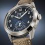 The Patek Philippe Complications 5328G-001 is a luxury wristwatch featuring a textured black dial and a brown leather strap.