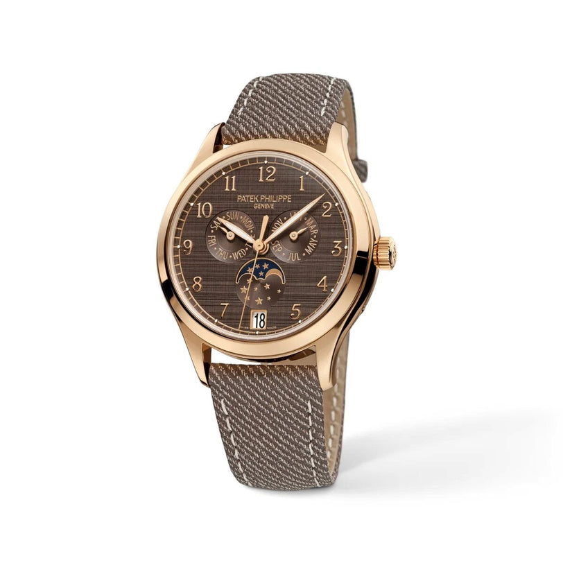 Patek Philippe Complications 4946R-001 wristwatch featuring a gold case, fabric strap, brown dial, and moonphase calendar.