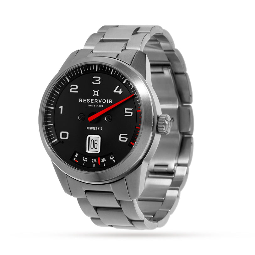 The Reservoir GT Tour is a silver metal wristwatch featuring a black dial, bold white numbers, and a date display above 6 o’clock.