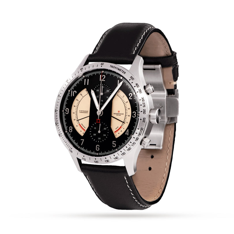 The Reservoir Sonomaster Chronograph Vintage is a luxury wristwatch featuring a black leather strap, black dial with cream subdials, and a stainless steel case.