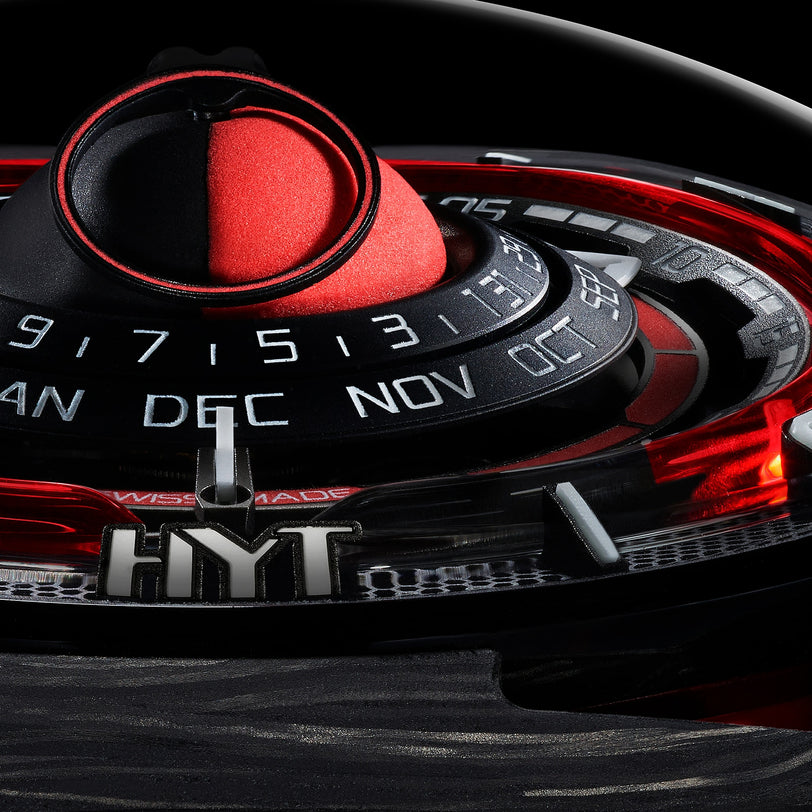 Close-up of the HYT Moon Runner Red Magma watch face, showcasing months and numbers with bold black and red details and the HYT logo.