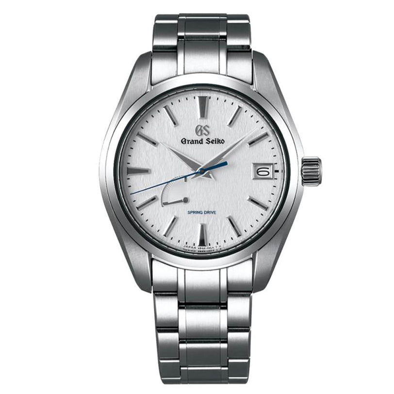 The Grand Seiko Spring Drive Heritage features a white textured dial, silver tone markers and hands, a blue seconds hand, date at 3 o’clock, and precise Spring Drive movement in a stainless steel case.