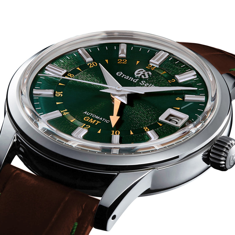 Close-up of the Grand Seiko Automatic GMT Elegance wristwatch, featuring a Mount Iwate dial in British Racing Green, gold GMT hand, date window, and brown leather strap.