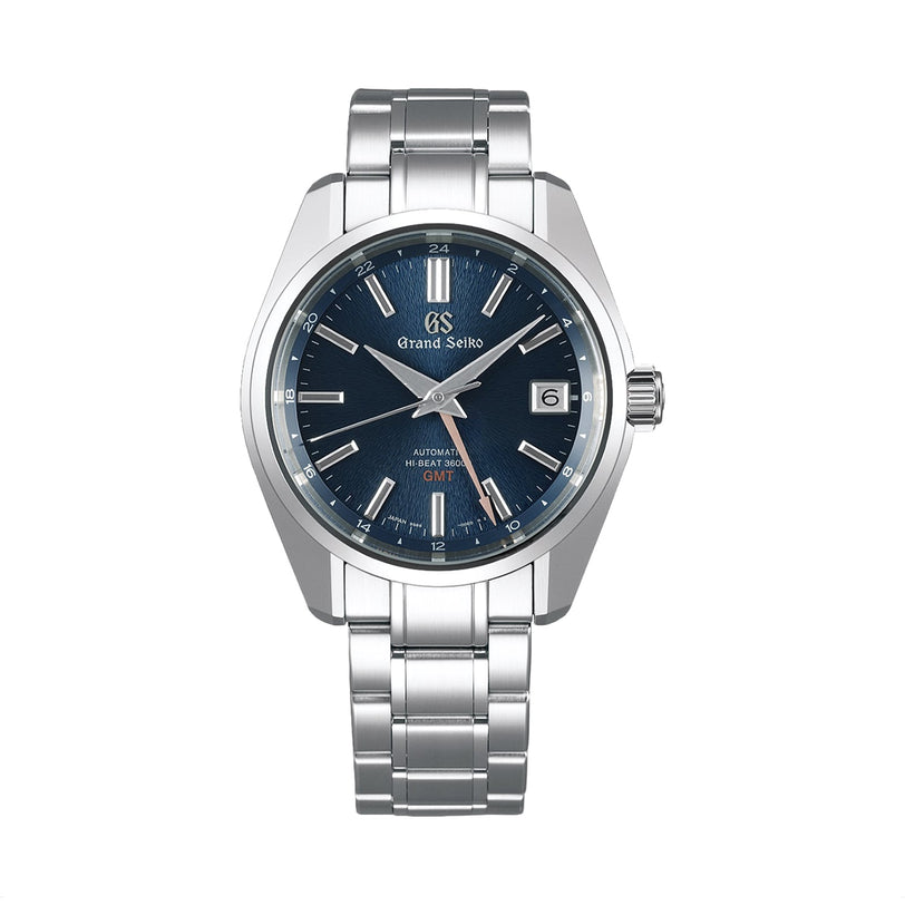 The Grand Seiko Hi-Beat GMT Heritage is a stainless steel wristwatch with a blue dial, silver indices, Zaratsu polishing, a date window at 3 oclock, and a sleek silver bracelet.