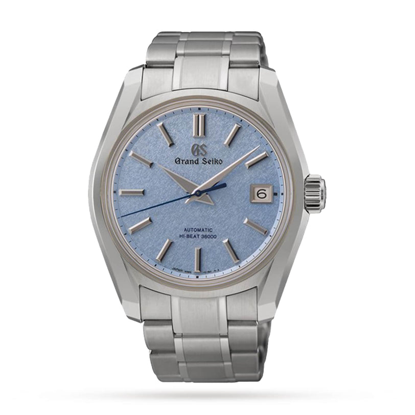 The Grand Seiko Hi-Beat Heritage is a stainless steel wristwatch featuring a light blue textured dial, silver hour markers, and a date window positioned at three o’clock.