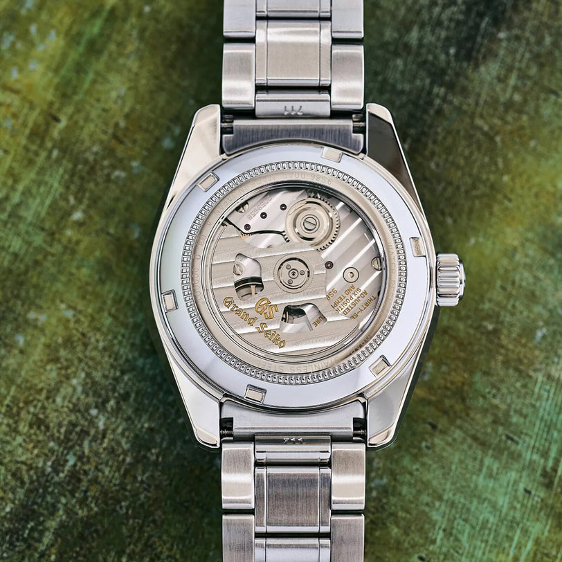 A close-up of the Grand Seiko Hi-Beat GMT Heritage’s stainless steel back displays the 9S86 mechanical movement through its transparent case back.